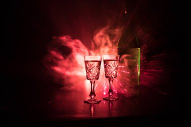 İki kadeh votka şişesiyle karanlık sisli parlayan ışıklar (lazer, Stobe) çok renkli stil arka plan kulübü. Kulüp tema dekorasyon içer. Boş alanı. Seçici odak