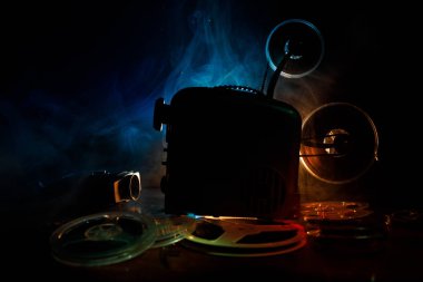 Eski stil film projektör, Natürmort, yakın çekim. Film projektör dramatik aydınlatma ve seçici odak ahşap bir zemin üzerine. Film ve eğlence kavramının