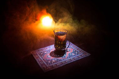 Geleneksel glasse ve ışıklar ve duman siyah zemin üzerine pot Doğu tea. Doğu çay kavramı. Armudu geleneksel Azerbaycan/Türkiye Kupası. Seçici odak. Bardak çay