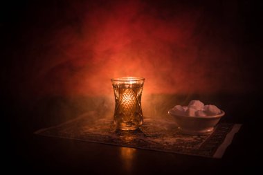Geleneksel glasse ve ışıklar ve duman siyah zemin üzerine pot Doğu tea. Doğu çay kavramı. Armudu geleneksel Azerbaycan/Türkiye Kupası. Seçici odak. Bardak çay