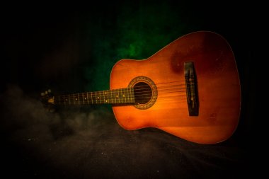 Müzik konsepti. Akustik gitar duman ile ışık altında karanlık bir arka plan üzerinde. Gitar dizeleri ile kapatın. Seçici odak. Yangın etkileri.