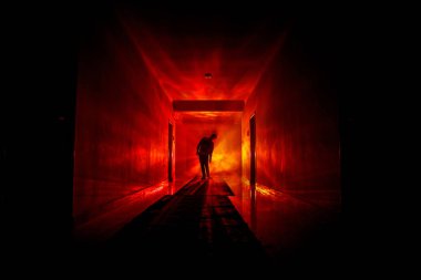 Ürpertici siluet koyu terk edilmiş binada. Kabine kapılar ve ışıkları ile farklı pozlar duran korkunç korku kişi silueti ile karanlık koridor.