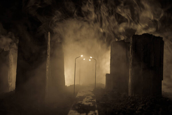 Empty street of burnt up city, flames on the ground and blasts with smoke in the distance. Apocalyptic view of city downtown as disaster film poster concept. Night scene. City destroyed by war.