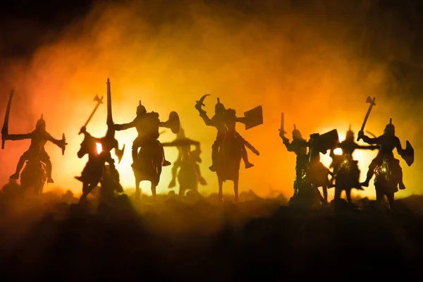 Scène de bataille médiévale avec cavalerie et infanterie. Silhouettes de figures comme objets séparés, lutte entre guerriers sur fond brumeux foncé. Scène nocturne . — Photo