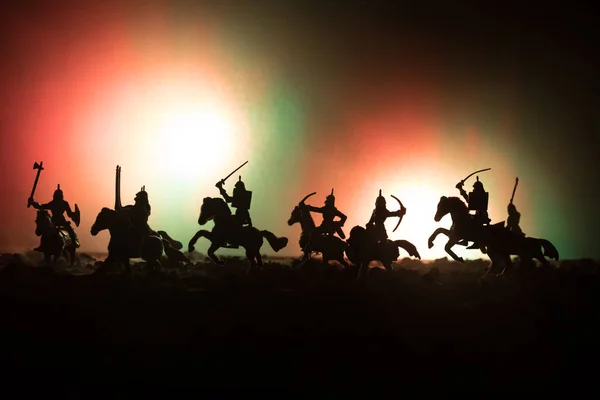 騎兵と歩兵の中世の戦闘シーン。個別のオブジェクトとして人物のシルエットは、暗いトーンの霧の背景に戦士の間戦います。夜のシーン. — ストック写真