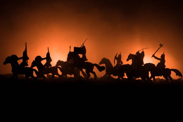 Cena de batalha medieval com cavalaria e infantaria. Silhuetas de figuras como objetos separados, luta entre guerreiros em fundo enevoado escuro. Cena noturna . — Fotografia de Stock