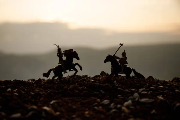 Joust antara dua ksatria menunggang kuda. Matahari terbenam di latar belakang. Fokus selektif — Stok Foto