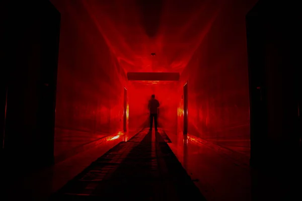 Silhouette raccapricciante nel buio edificio abbandonato. Corridoio scuro con porte armadio e luci con silhouette di persona orrore spettrale in piedi con pose diverse . — Foto Stock