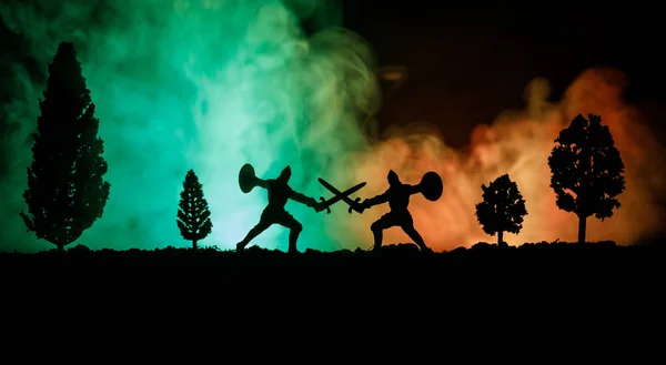 Scène de bataille médiévale avec cavalerie et infanterie. Silhouettes de figures comme objets séparés, lutte entre guerriers sur fond brumeux foncé. Scène nocturne . — Photo