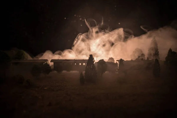 Zug bewegt sich im Nebel. Alte Dampflokomotive in der Nacht. Nachtzug fährt auf der Eisenbahn. getönten nebligen Brandhintergrund. Horror-Szene. — Stockfoto