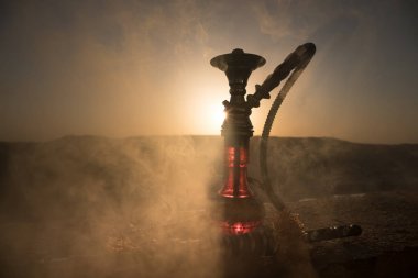 Nargile, geleneksel Arapça harcamak, doğrudan günbatımı güneş ışığı, açık fotoğraf. Dağ arka plan veya nargile günbatımı arka plan üzerinde siluetleri. Açık.