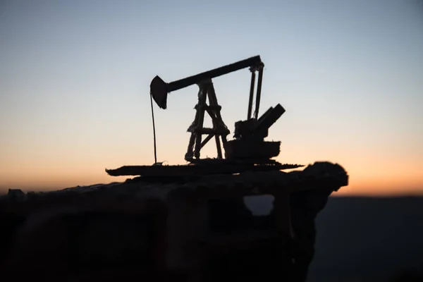 Decoração de madeira. Máquina industrial da energia do equipamento de óleo da bomba de óleo para o petróleo no fundo do por do sol para o projeto — Fotografia de Stock