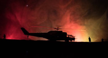 Askeri helikopter çatışma bölgesinden uçmaya hazır silüeti. Gece görüntüleri çöl sisli tonda sırt ile başlayarak helikopter ile dekore edilmiştir. Seçici odak.