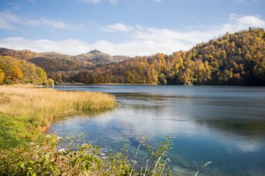 Göl ve dağlarla sakin bir akşam manzarası. Ganja, Azerbaycan 'daki renkli sonbahar ormanları arasında Goy-Gol Gölü' nün (Mavi Göl) inanılmaz manzarası.