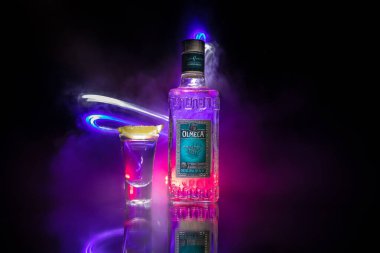 Bakü, Azerbaycan - 16 Haziran. 2019. Koyu tonda sisli arka plan üzerinde ahşap masa üzerinde Olmeca Tekila. Olmeca Tekila Jalisco, Meksika'da üretilen bir tekila.