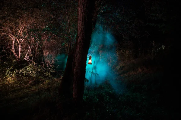Concepto de Halloween de horror. Quema vieja lámpara de aceite en el bosque por la noche. Paisaje nocturno de una escena de pesadilla . — Foto de Stock