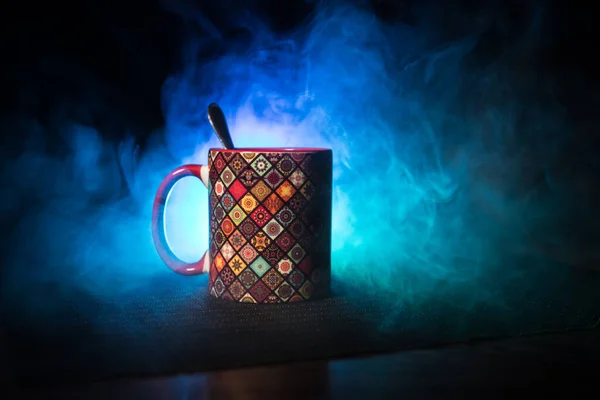 Krásný východní styl s keramickým šálkem kávy (nebo čaje) s kouřem přes tmavě tónové pozadí. — Stock fotografie