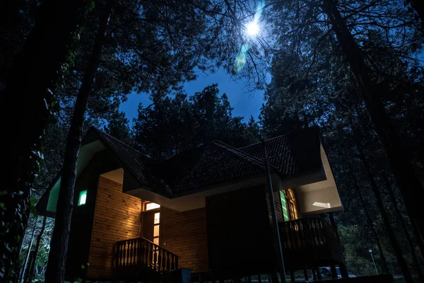 Stary straszny dom w lesie sosnowym w nocy. Koncepcja Halloween horror — Zdjęcie stockowe