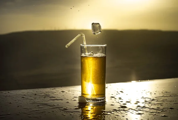 Raffreddamento concetto di bevanda estiva. Bicchieri da cocktail che schizzano al tramonto. Chiudi il bicchiere bagnato di bevanda fredda sulla terrazza . — Foto Stock