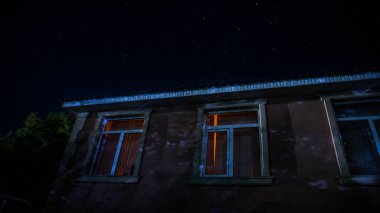 Geceleri ormanda bir hayaletin olduğu eski bir ev ya da sis içinde terk edilmiş bir korku evi. Ölü ağaç ormanındaki eski mistik bina. Geceleri aylı ağaçlar. Gerçeküstü ışıklar. Korku Cadılar Bayramı konsepti