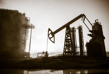Yaratıcı sanat dekorasyonu. Petrol pompası ve petrol arıtma fabrikası gün batımında. Enerji endüstrisi konsepti. Seçici odak.