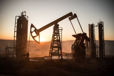 Yaratıcı sanat dekorasyonu. Petrol pompası ve petrol arıtma fabrikası gün batımında. Enerji endüstrisi konsepti. Seçici odak.