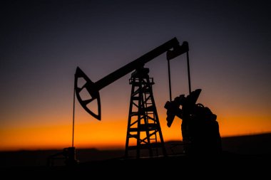 Yaratıcı sanat dekorasyonu. Petrol pompası ve petrol arıtma fabrikası gün batımında. Enerji endüstrisi konsepti. Seçici odak.