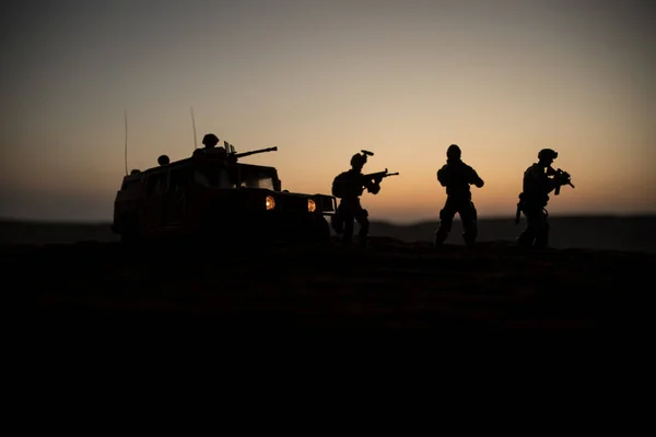 Un patrullero militar al atardecer. Concepto de guerra del ejército. Silueta de vehículo blindado con soldados listos para atacar. Decoración de obra. Enfoque selectivo — Foto de Stock