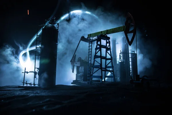 Kunstwerk decoratie. Oliepomp en olieplatform energie industriële machines voor aardolie 's nachts met mist en achtergrondverlichting. Olie raffinaderij. Energie-industrieel concept. Selectieve focus — Stockfoto