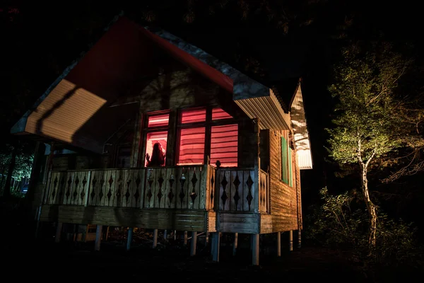 Geceleri ormanda bir hayaletin olduğu eski bir ev ya da sis içinde terk edilmiş bir korku evi. Ölü ağaç ormanındaki eski mistik bina. Geceleri aylı ağaçlar. Gerçeküstü ışıklar. Korku Cadılar Bayramı konsepti — Stok fotoğraf