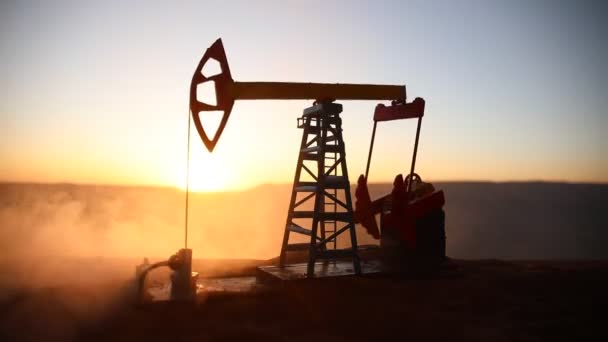 日没時の石油ポンプと石油精製工場のシルエット — ストック動画