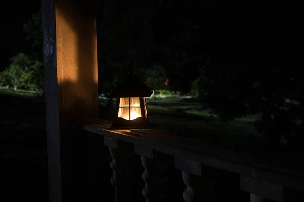 Retro style lantern at night. Beautiful colorful illuminated lamp at the balcony in the garden. — Stock Photo, Image