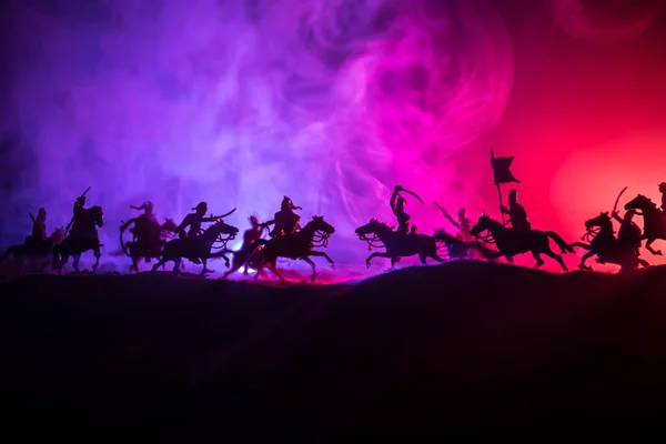 Medieval battle scene with cavalry and infantry. Silhouettes of figures as separate objects, fight between warriors on dark toned foggy background. Night scene. — Stock Photo, Image