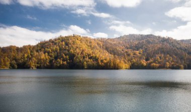 Göl ve dağlarla sakin bir akşam manzarası. Ganja, Azerbaycan 'daki renkli sonbahar ormanları arasında Goy-Gol Gölü' nün (Mavi Göl) inanılmaz manzarası.