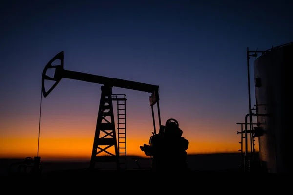 Yaratıcı sanat dekorasyonu. Petrol pompası ve petrol arıtma fabrikası gün batımında. Enerji endüstrisi konsepti. Seçici odak. — Stok fotoğraf