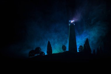 Sis ile gece ışık demeti ile deniz feneri. Eski feneri ayakta Dağı'nda. Masa dekorasyonu. Tonlu arka plan. Ek iş.