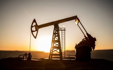 Yaratıcı sanat dekorasyonu. Petrol pompası ve petrol arıtma fabrikası gün batımında. Enerji endüstrisi konsepti. Seçici odak.