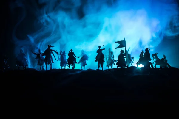 Scena di battaglia medievale con cavalleria e fanteria. Silhouette di figure come oggetti separati, lotta tra guerrieri su sfondo nebbioso dai toni scuri. Scena notturna . — Foto Stock