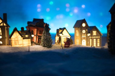 Yeni yıl minyatür evi, geceleri karlı ve köknar ağacıyla kaplı..