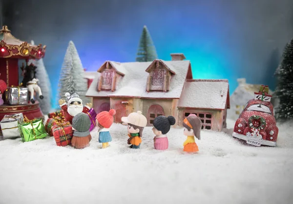 Koncepcja świąt Bożego Narodzenia i Nowego Roku. Małe dekoracyjne słodkie domki w śniegu w nocy w zimie, Drzewo jodłowe stojące na śniegu z pięknym tle urządzone wakacje — Zdjęcie stockowe