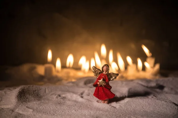 Little white guardian angel in snow. Festive background. Christmas and New Year concept. Selective focus