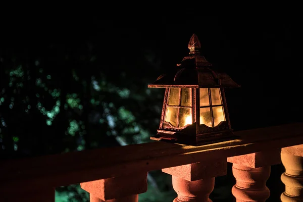 Lucerna v noci. Krásná barevná osvětlená lampa na balkóně v zahradě. — Stock fotografie