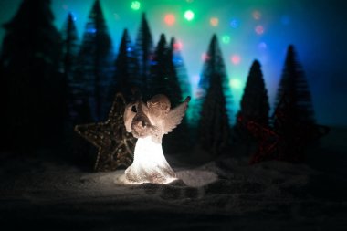 Kardaki küçük beyaz koruyucu melek. Şenlik arka planı. Noel süslemeleri.