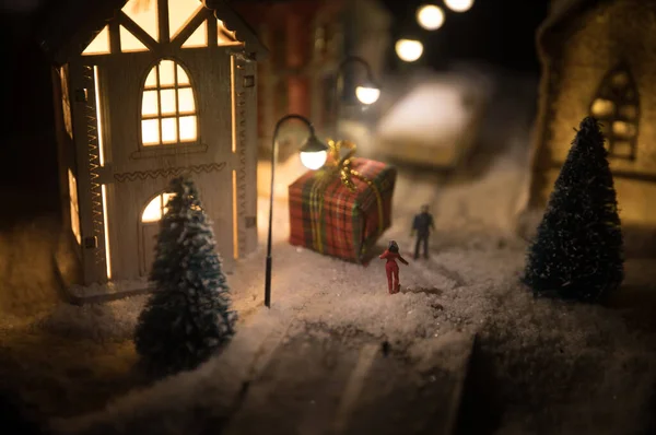 Новогодний миниатюрный домик в снегу ночью с елкой. Концепция праздника. Селективный фокус — стоковое фото