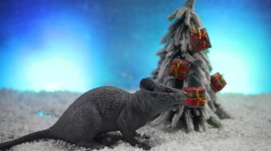 Noel süsleri ve Noel Baba 'yla etrafta süslü kahverengi bir fare var. Fare, 2020 yılının bir sembolü.