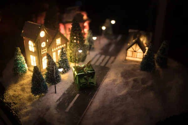 Casa in miniatura di anno nuovo nella neve di notte con abete. Concetto vacanza. Focus selettivo — Foto Stock