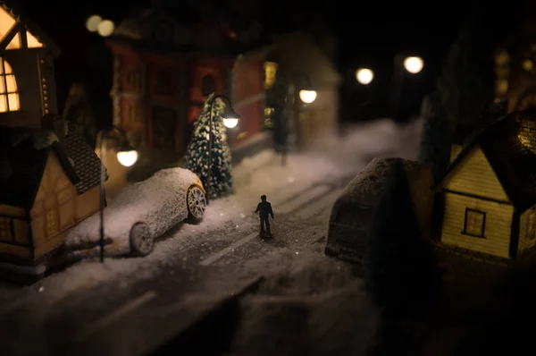 Casa en miniatura de Año Nuevo en la nieve por la noche con abeto. Concepto de vacaciones. Enfoque selectivo — Foto de Stock