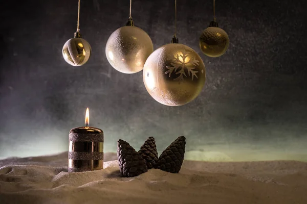 創造的なアートワーク装飾。暗い背景に燃えるろうそくとクリスマスの装飾。ライトと暗い黄金の背景の上にクリスマスオーナメント. — ストック写真