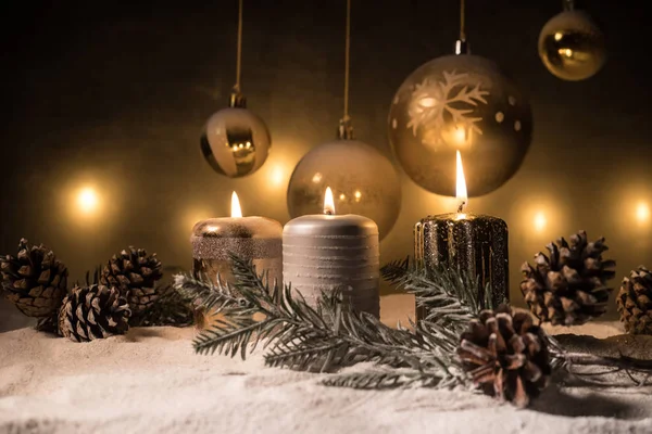 Decoração de arte criativa. Decoração de Natal com velas acesas em um fundo escuro. Enfeites de Natal sobre fundo dourado escuro com luzes . — Fotografia de Stock