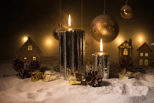 Decoración artística creativa. Decoración navideña con velas encendidas sobre un fondo oscuro. Adornos navideños sobre fondo dorado oscuro con luces . —  Fotos de Stock